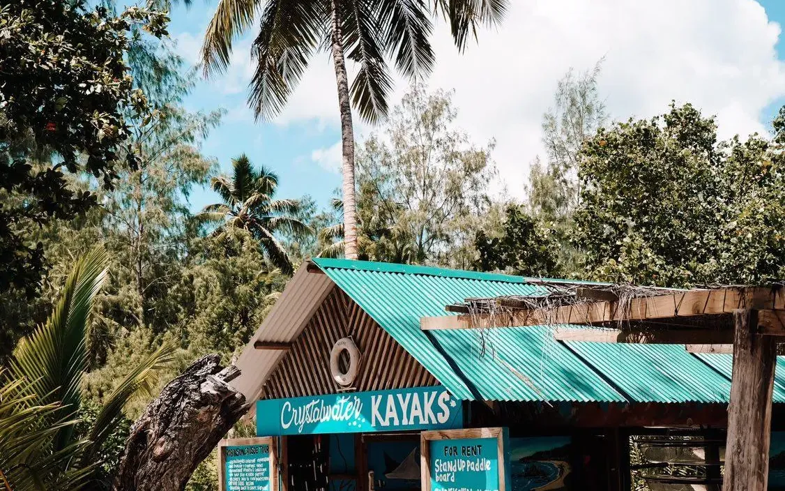 The Crystal Water Kayaks base beneath palms at Anse Source d’Argent