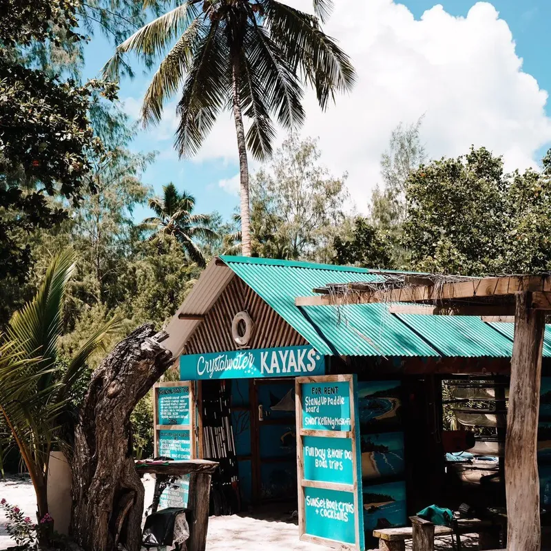 The Crystal Water Kayaks base beneath palms at Anse Source d’Argent